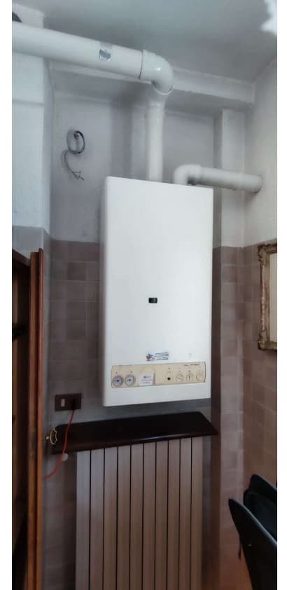 Generatore murale a gas e radiatore prima della riqualificazione con pompa di calore a Cantalupa