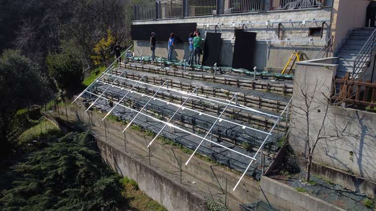 Realizzazione fotovoltaica iS ENERGY a San Pietro Val Lemina: Vista obliqua del cantiere che mostra la posa su superficie inclinata e non convenzionale.