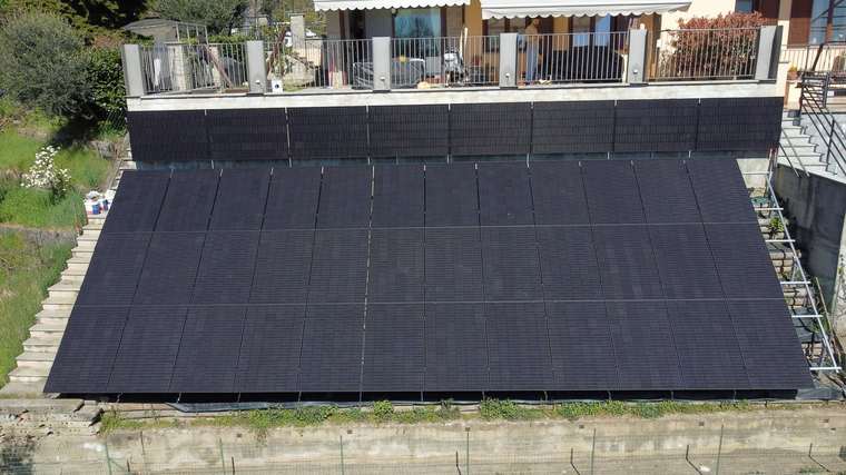 Realizzazione fotovoltaica iS ENERGY a San Pietro Val Lemina: Dettaglio frontale dell impianto finito, con campo FV ordinato e continuita visiva sulla struttura inclinata.