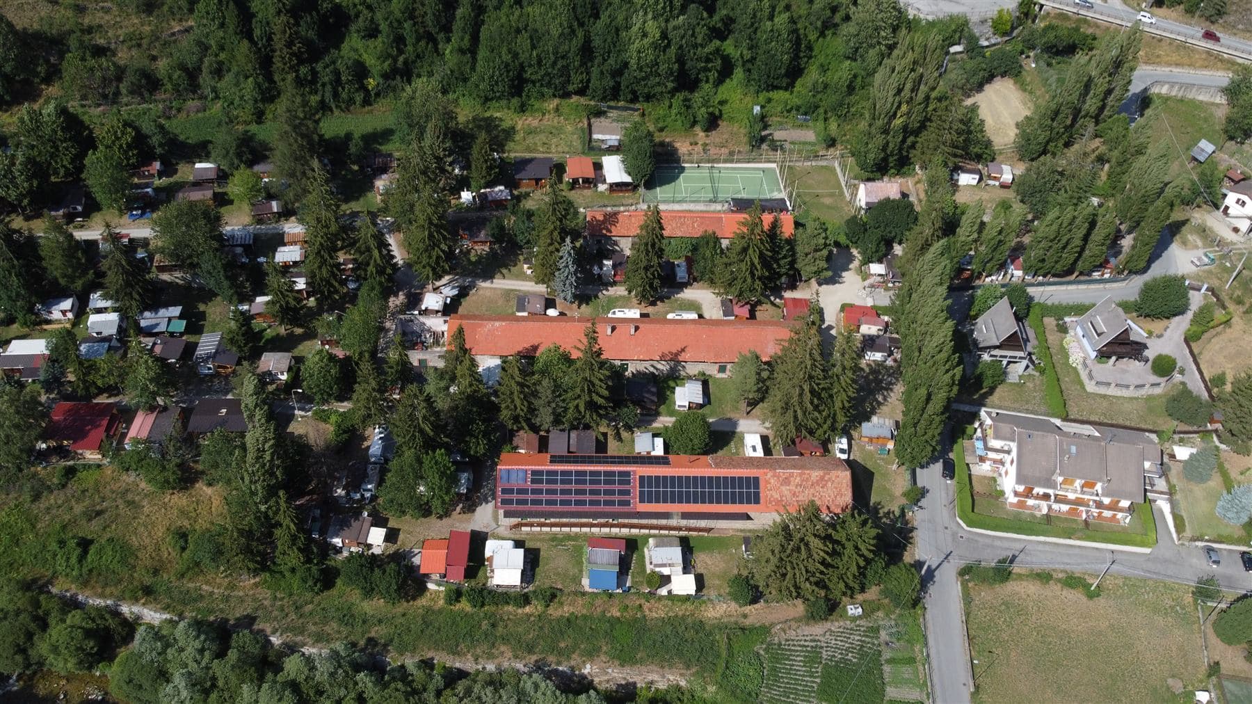 Vista aerea ampia del campeggio con impianto fotovoltaico e aree esterne