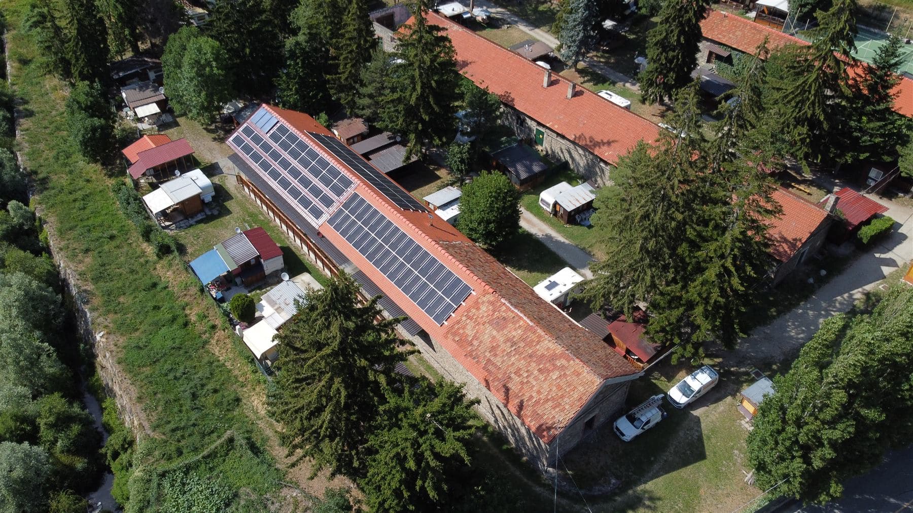 Ripresa drone laterale del campeggio con campo fotovoltaico sul tetto